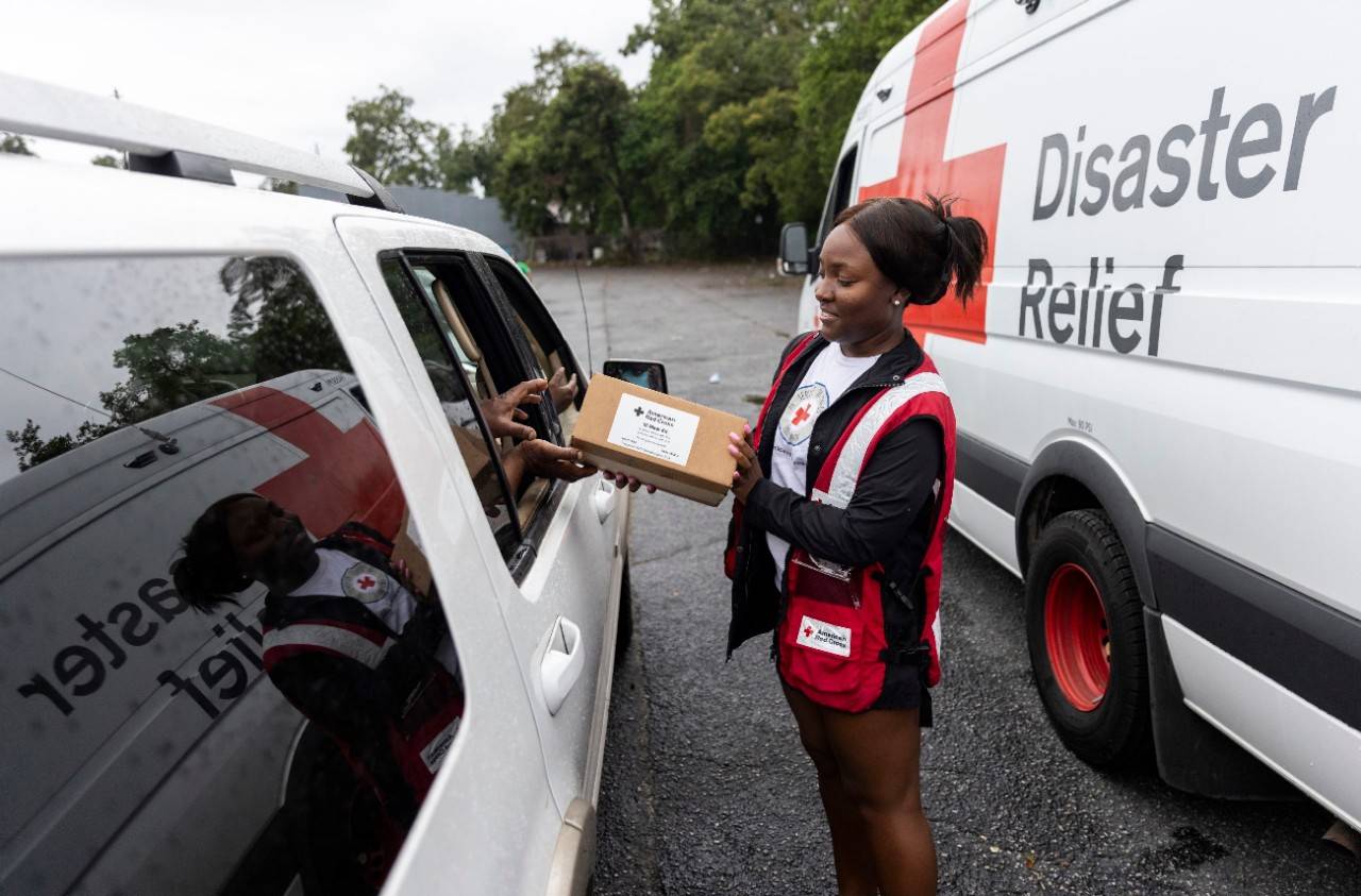 September 1, 2023. Valdosta, Georgia.
Red Cross disaster responder, Amiya Miles, hands meal kits to residents of Valdosta, Georgia, at a drive-thru distribution site set up in the parking lot of a local church. Valdosta is one of the many communities which was hit hard by Hurricane Idalia and is being helped by the Red Cross. Due to the climate crisis, hurricanes are becoming more intense and destructive with higher rainfall and storm surges.
Photo by Scott Dalton/American Red Cross