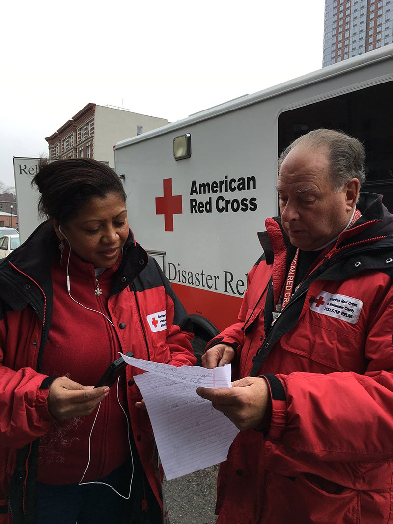 2 Red Cross volunteers looking at paperwork together