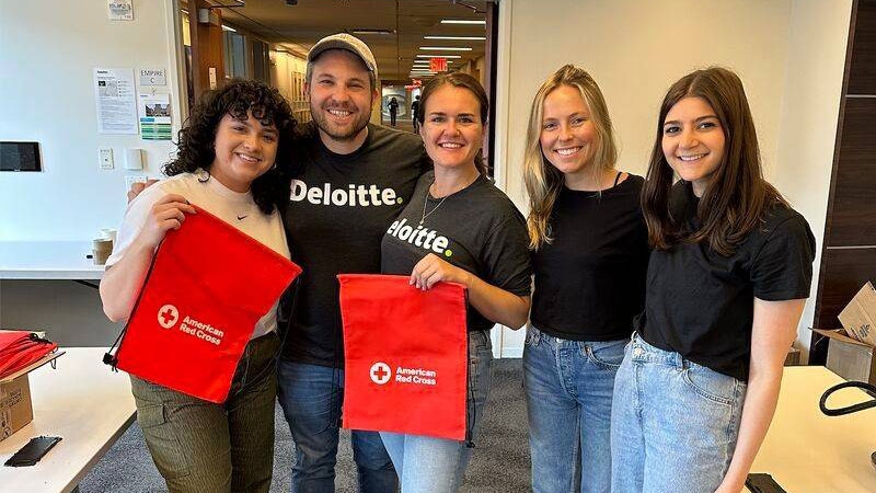 Group photo with 2 people holding American Red Cross cloth bags
