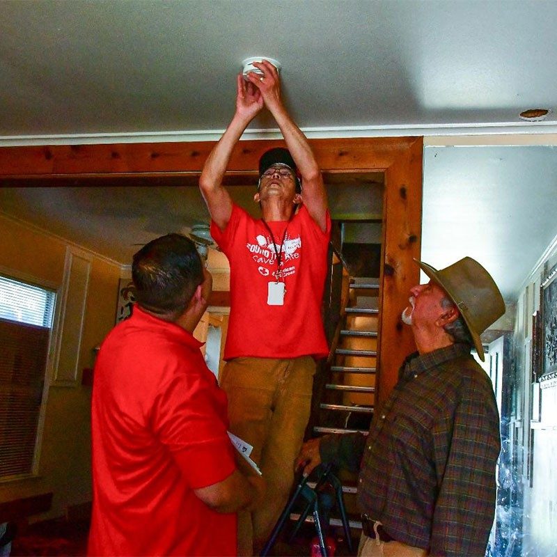 Red Coss volunteers installang smoke alarm