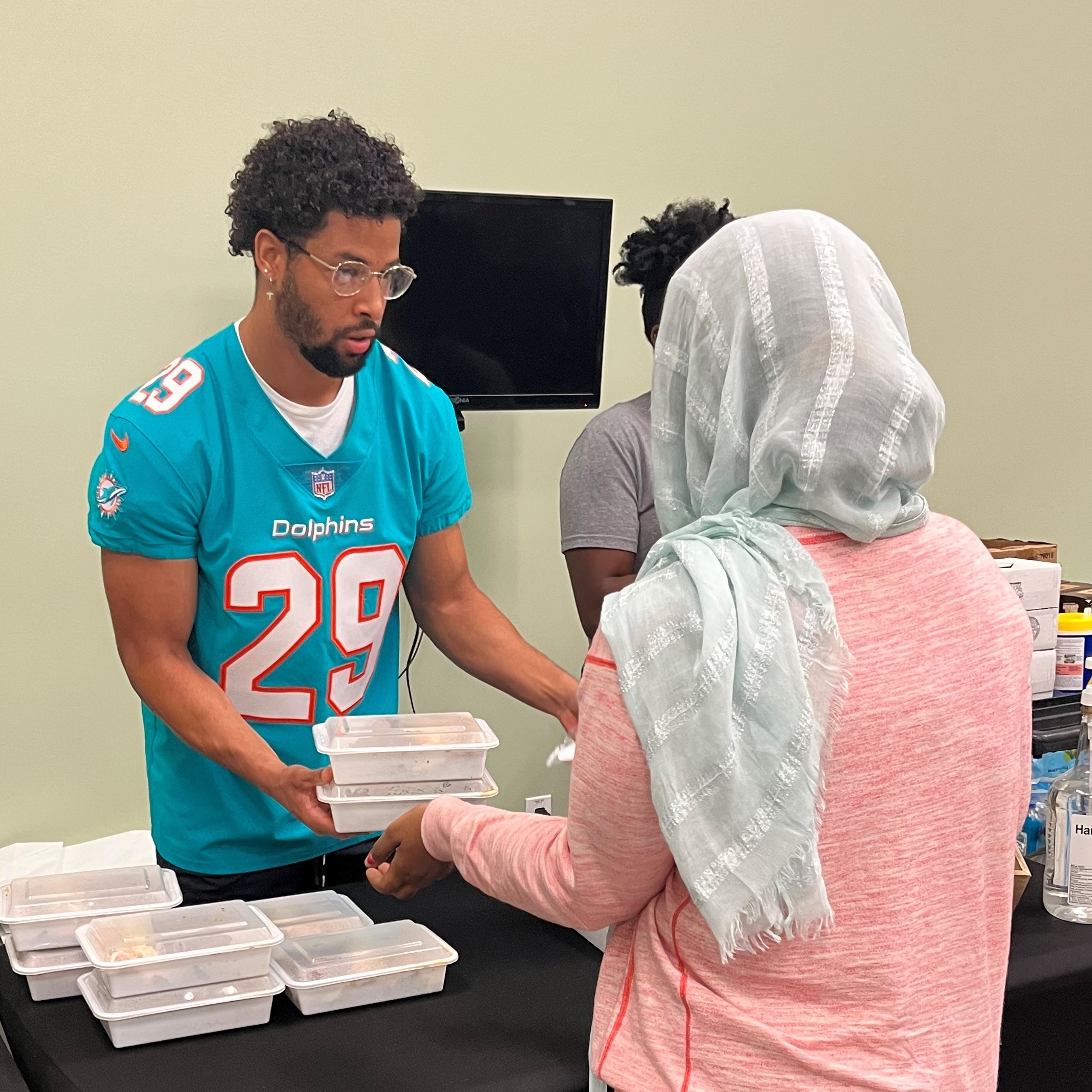 Miami Dolphins football player Brandon Jones serving dinner at Red Cross shelter
