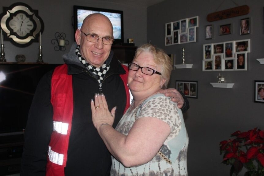 A red cross volunteer hugging a client and smiling