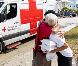 person gets hug from red cross volunteer