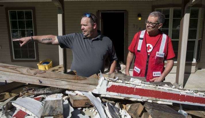 Chris Strong shows Marco Bracamontes of the American Red Cross how his house was damaged by Hurricane Harvey, in Vidor, TX.
