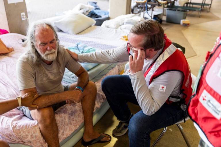 A man chokes up while talking to an American Red Cross staff member
