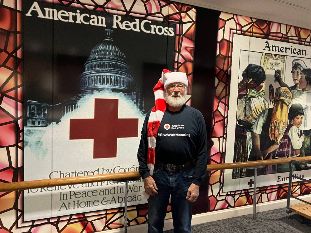 Dave Barman is standing in front of several historic American Red Cross posters