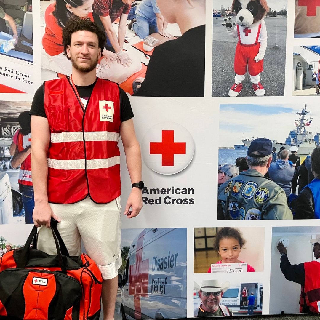 volunteer in front of red cross mural