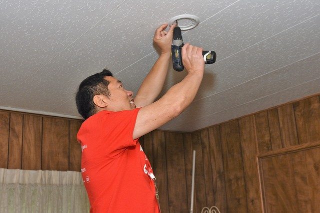 Red Cross volunteer installing smoke alarm on ceiling