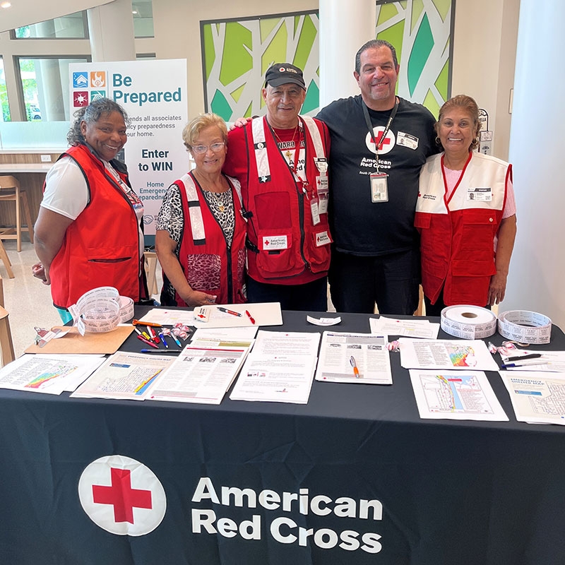 group of Red Cross volunteers at a table with Red Cross pamphlets.