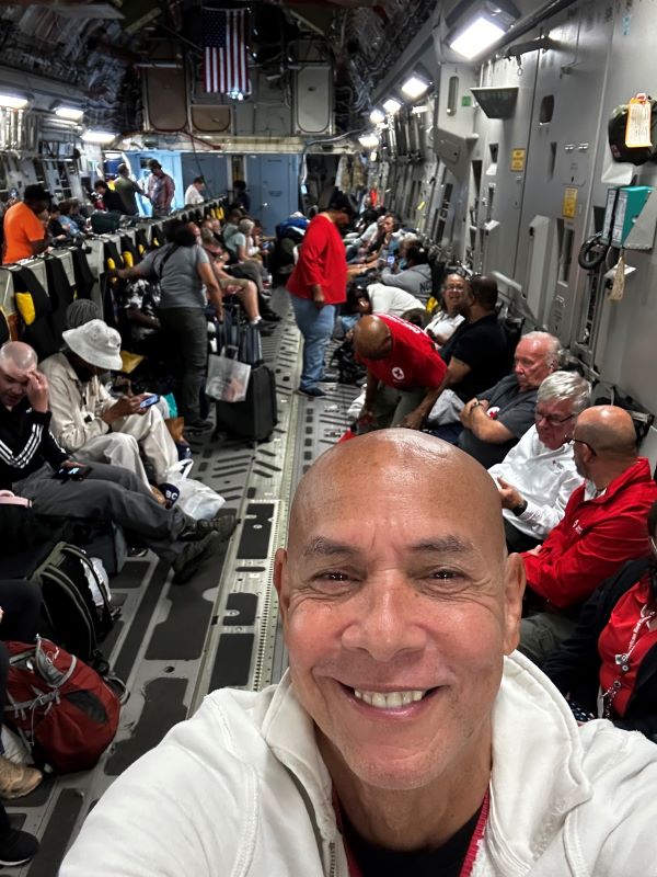 Ray smiling looking at the camera in a cargo plane