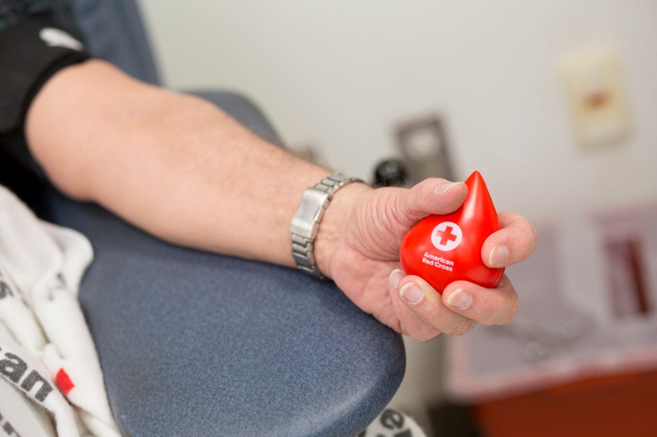 Hand squeezing Red Cross blood drop shaped stress ball
