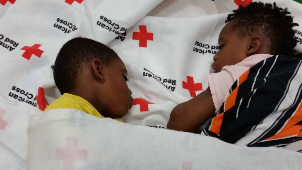Young Chris and Frederick Moore and their family escape the chaos of the ongoing severe weather in Houston in an American Red Cross Respite Center near their home.