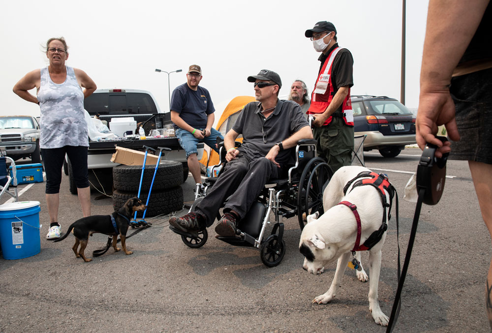 Volunteer makes sure Greg Norton is comfortable in his  wheelchair 