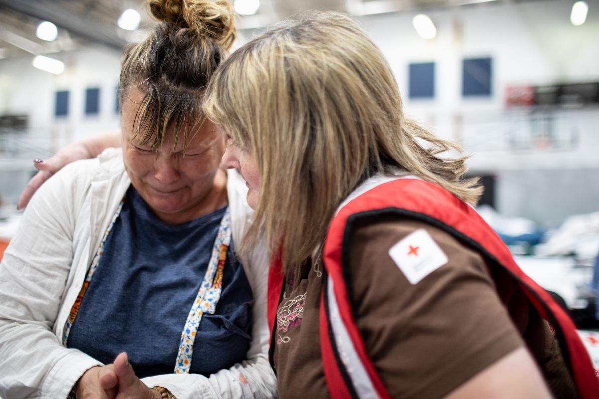 Red Cross volunteer comforting a crying Jennifer Walker in an American Red Cross shelter..