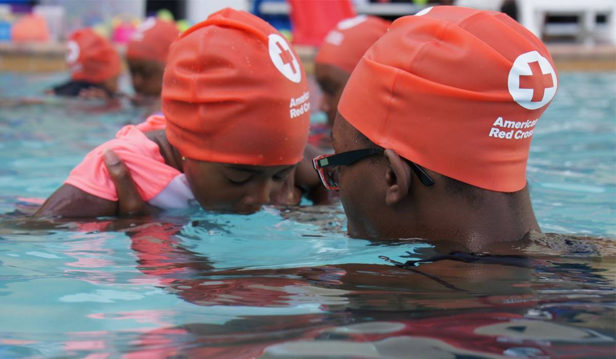 A young child taking a swim Red Cross class and learning to swim