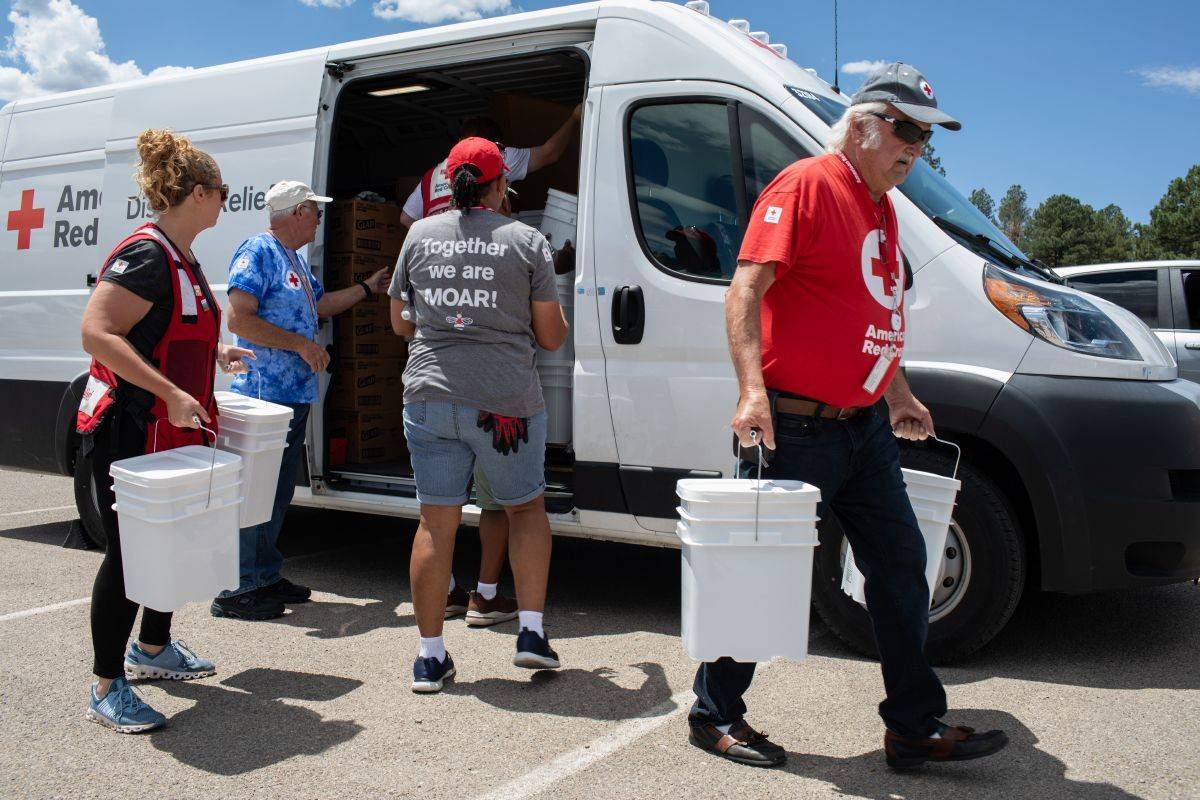 Red Cross volunteers distribute cleanup supplies to residents of Ruidoso, New Mexico as they returned home