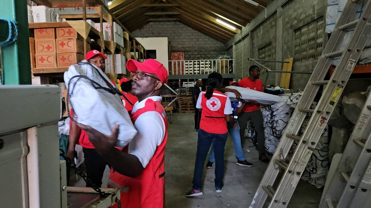 Several members of the Grenada Red Cross Society wear their Red Cross red vests as they work in the Red Cross warehouse in Grenada, getting relief supplies ready to send by boat to areas of the island damaged by Hurricane Beryl