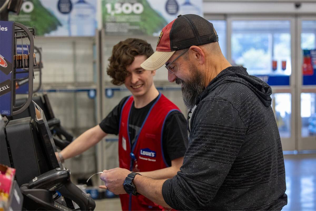 A Lowe's employee is assisting a customer in a Lowe's store