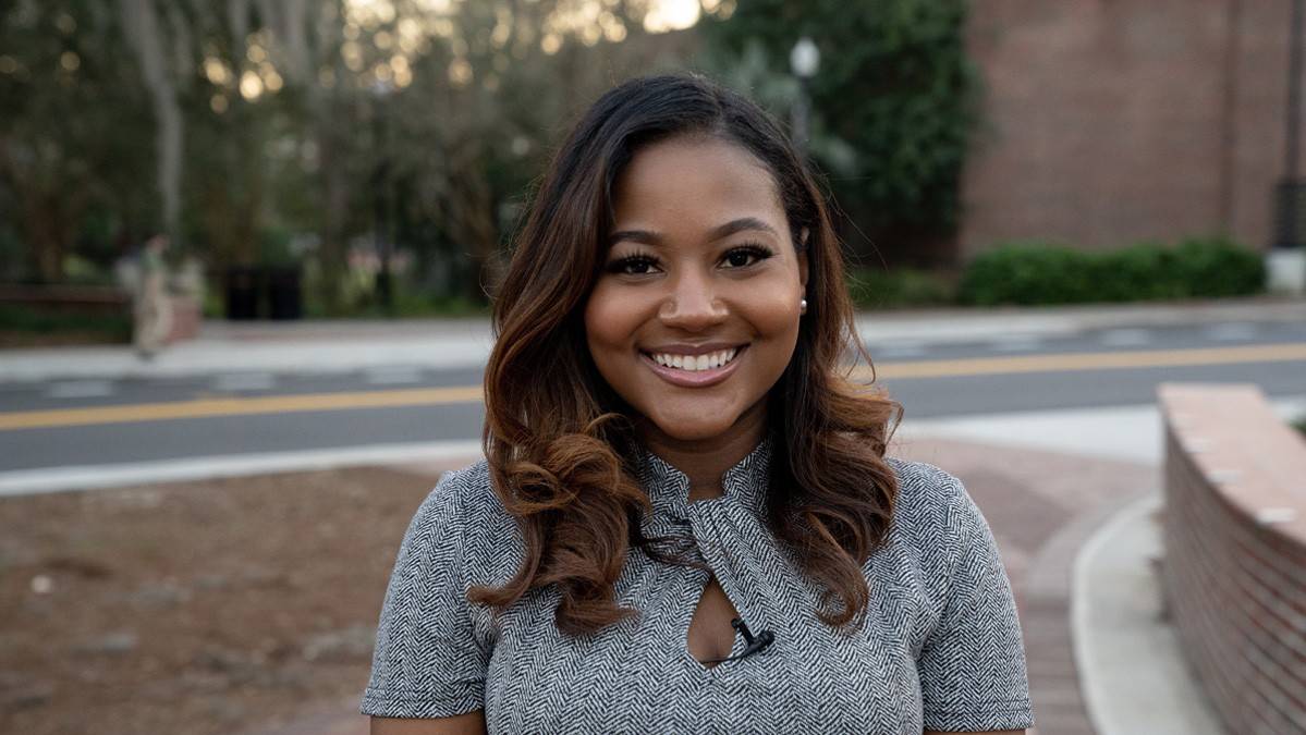 Lyric Porter is posing for a picture, she is smiling and appears very happy