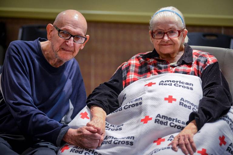 Patrick and Geraldine Riley, hold hands at the St. Cloud Senior Center shelter 