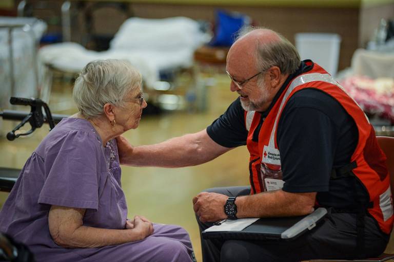 Red Cross volunteer Bob Wallace chats with Virginia Marciniak