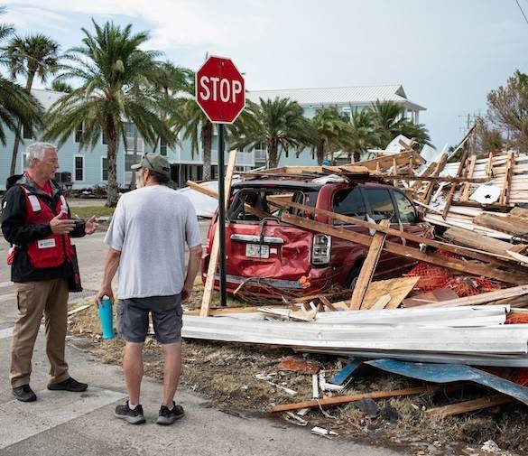 A Red Cross disaster relief volunteer and client survey damage from Hurricane Helene