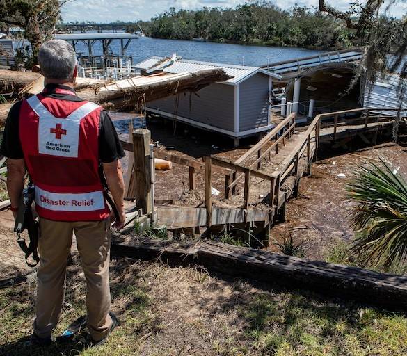 A Red Cross disaster relief volunteer surveys damage from Hurricane Helene