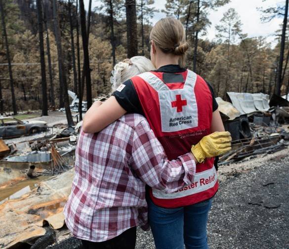 A Red Cross volunteer comforts a person affected by wildfire