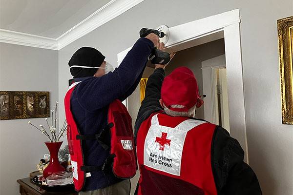 Red Cross volunteers installing smoke alarm