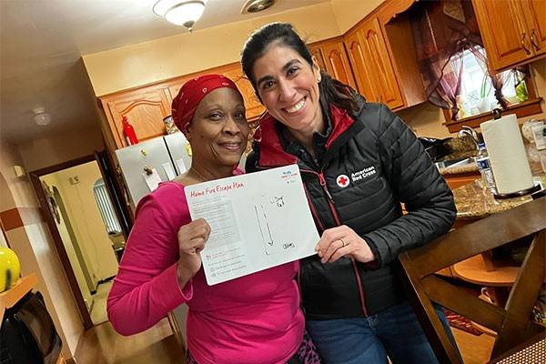Resident and Red Cross volunteer holding up completed home fire escape plan