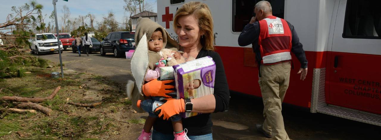 January 28, 2017.  Albany, Georgia. Sixteen-month-old Cayli, held by her neighbor Beverly Presley, receives diapers and snacks from Red Cross volunteer Jennifer Briggs. Photo by Daniel Cima for the American Red Cross