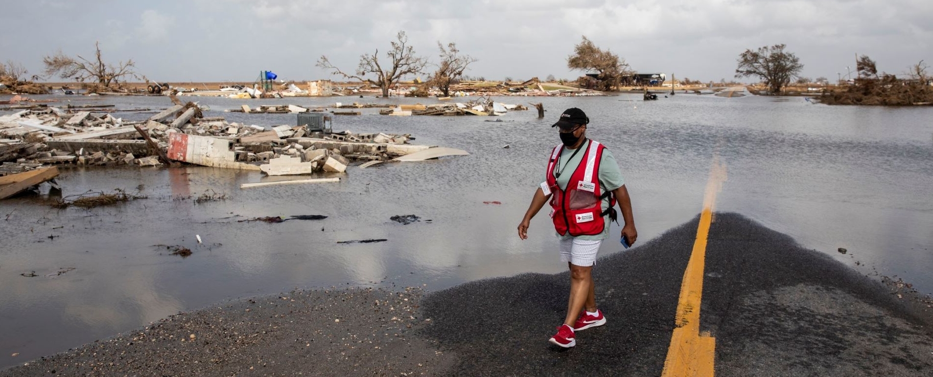 red cross volunteer surveying hurricane damage and flooded street