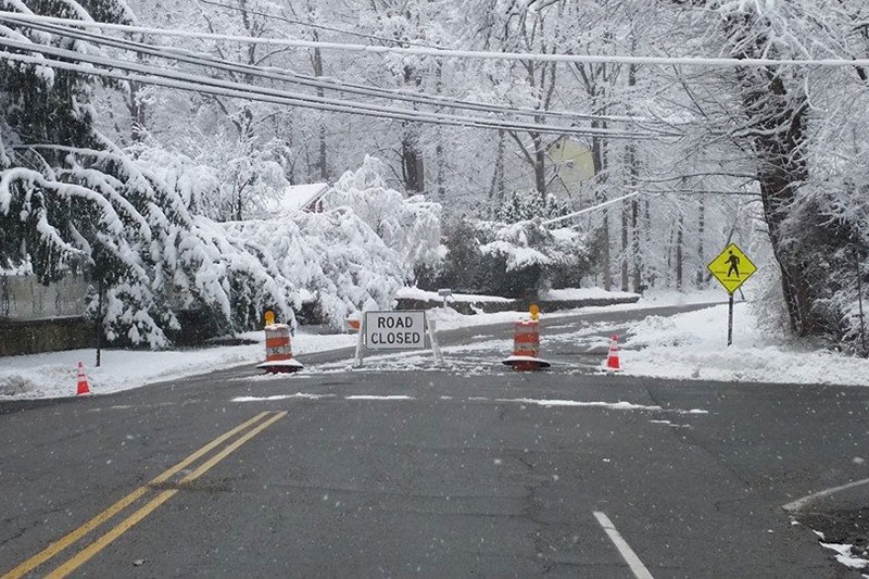 Road closed sign on a snowy road.