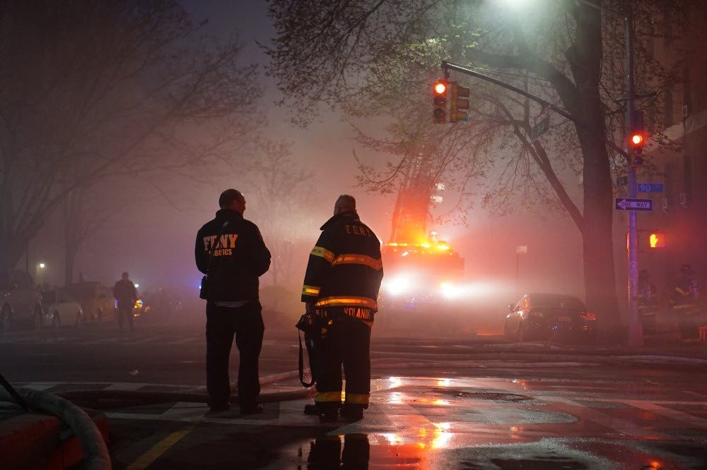 Two firefighters standing at a home fire