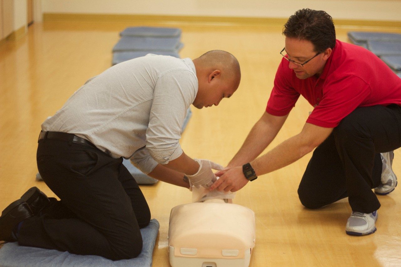 Student in a Red Cross CPR class practicing on a mannequin