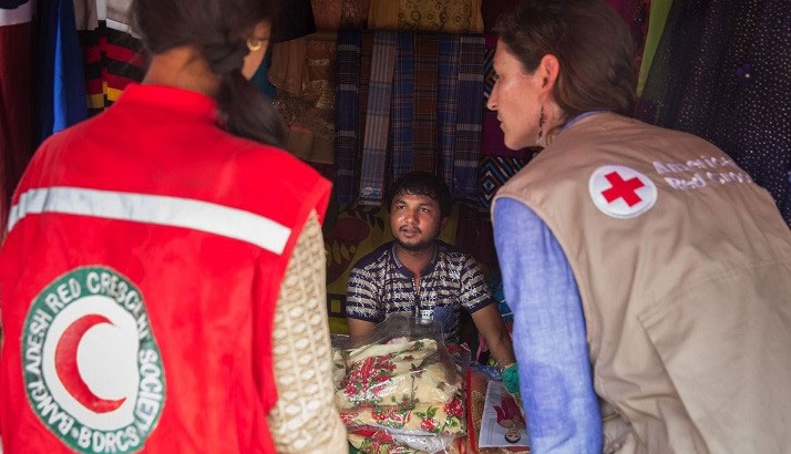 Red Cross volunteers speaking to person.