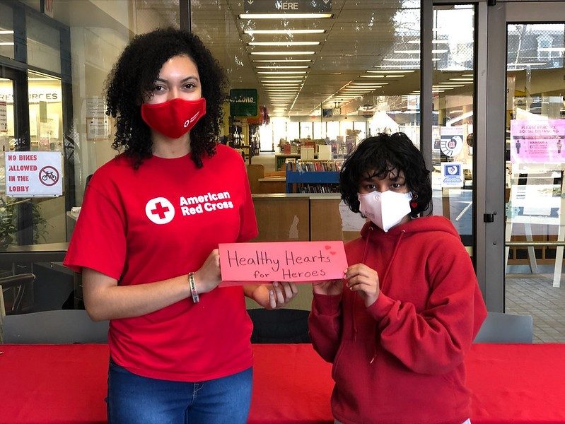 two red cross youth volunteers giving a thumbs up
