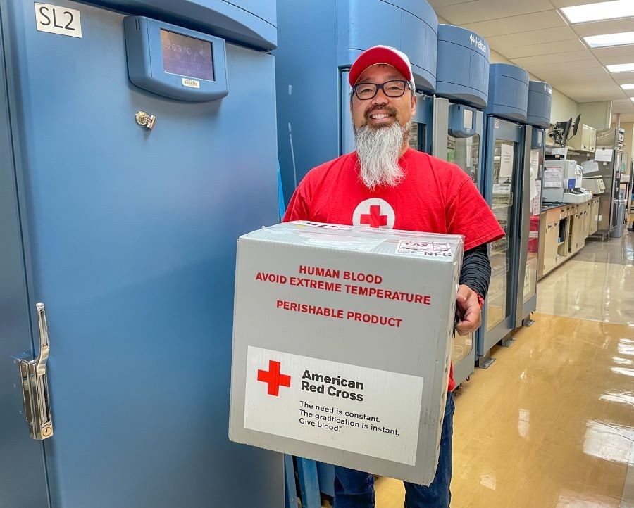 red cross volunteer carrying blood supplies to hospital