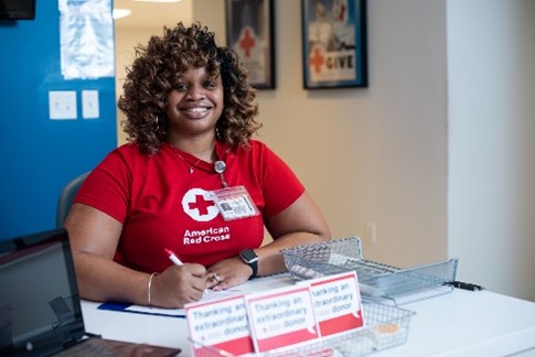 red cross volunteer smiling siting at desk