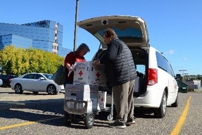 two red cross volunteers transporting blood products