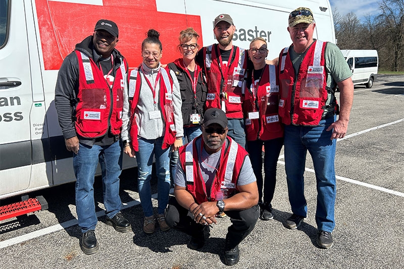 Red Cross volunteers standing next to Red Cross Disaster Vehicle