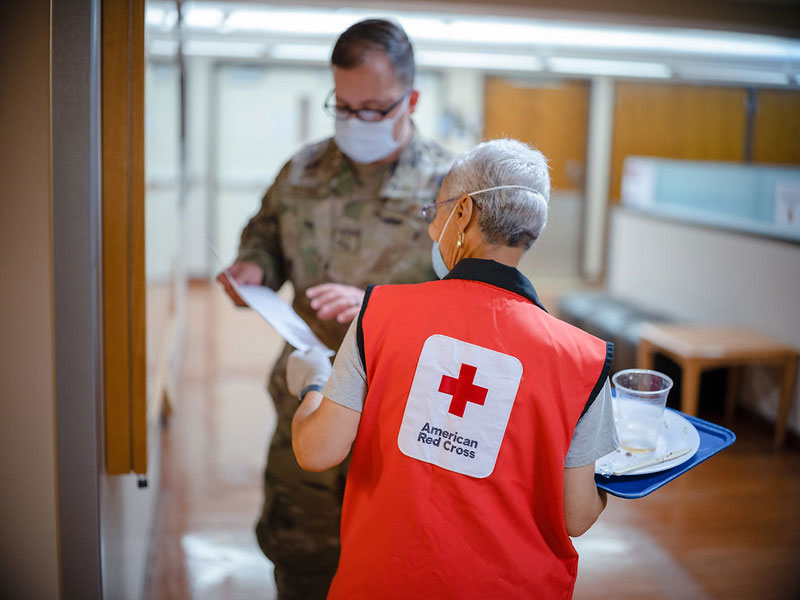 Red Cross volunteer speaking with military member