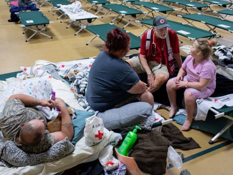 volunteer sitting with family at shelter