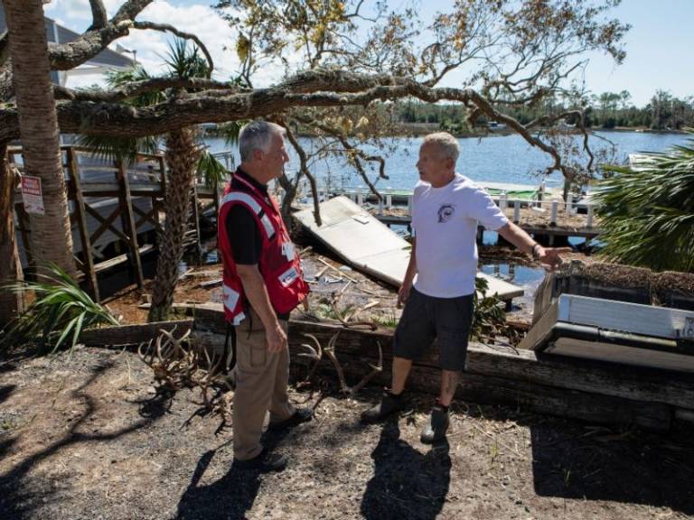 volunteer speaking with resident at scene of damaged home