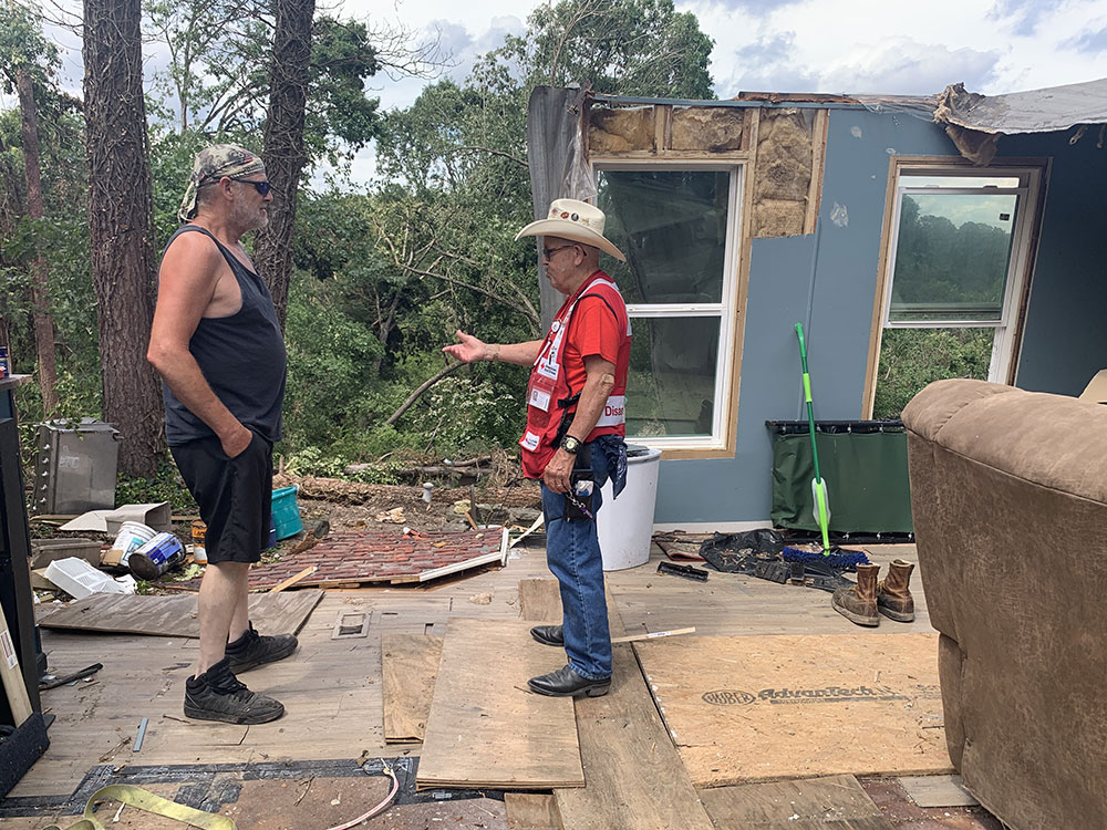 Red Cross volunteer talks to John Molz in demolished home