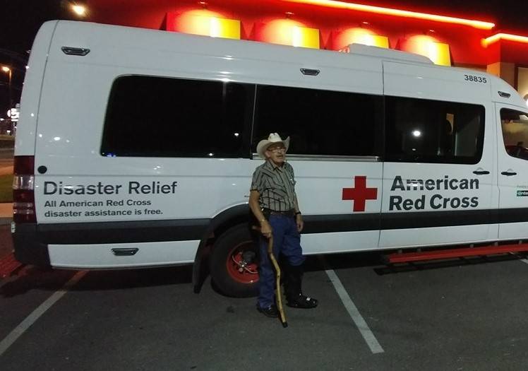 Tom Shands standing in front of red cross emergency vehicle