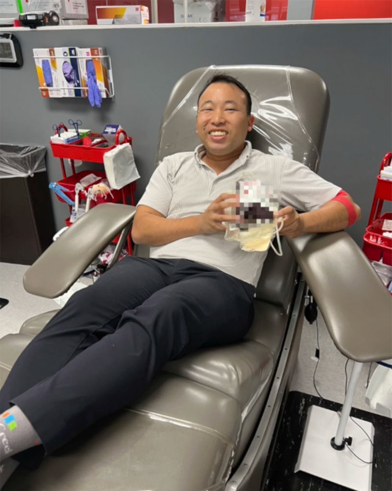 Eddi Lai in chair holding donated blood