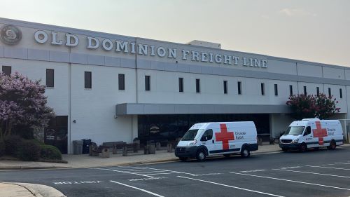 image of two red cross emergency vehicle in front of old dominion building 