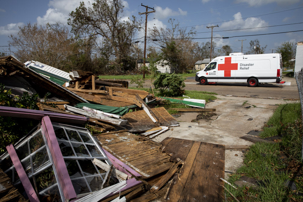 Red Cross emergency response vehichle parked outside a hurricane damaged home in Louisiana.