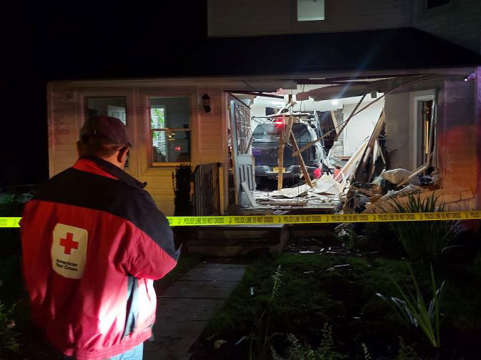 A Red Cross responder looks at the damage after a drunk driver crashed into Martha Richardson’s home in Huntington, NY.